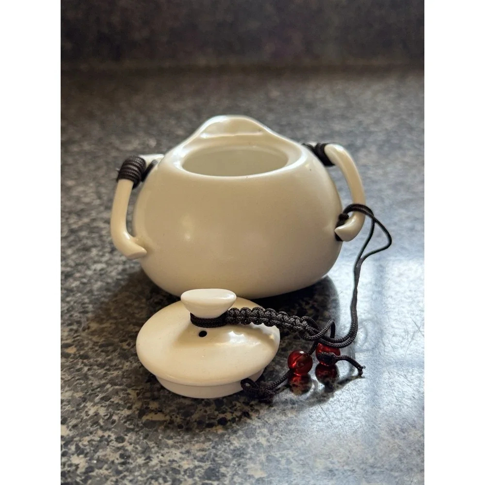 Compact travel tea pot white ceramic with decorative cord